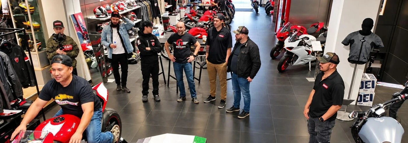 Jezdec v náklonu na simulátoru v motocyklovém showroomu